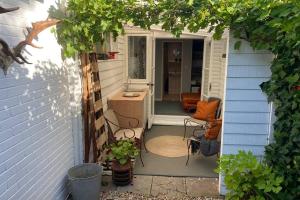 una pequeña entrada a una casa con porche en The Yellow Door Whitstable - Peaceful retreat close to beach en Whitstable