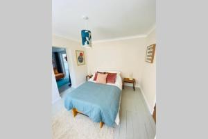 um quarto com uma cama com um cobertor azul em The Yellow Door Whitstable - Peaceful retreat close to beach em Whitstable