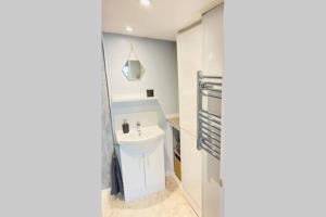 a bathroom with a white sink in a room at The Yellow Door Whitstable - Peaceful retreat close to beach in Whitstable +28 photos
