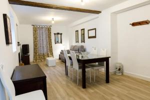 a dining room and living room with a table and chairs at Alojamiento Rural Casa Triana in Pegalajar