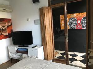 1 dormitorio con 1 cama y TV en un armario en Suite Artigas, en Colonia del Sacramento