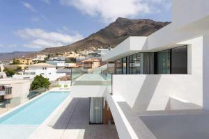 een wit huis met een zwembad en een berg bij New Home Costa Adeje Luxurious Private Villa in Adeje