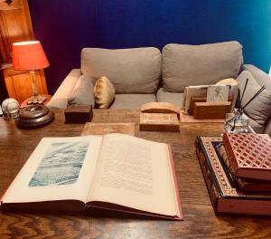 een open boek op een tafel met een bank bij Le Petit Bali Spacieuse Villa pour 8 avec Piscine in Saint Cyprien Plage