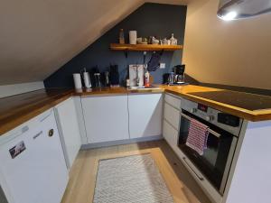 a kitchen with white cabinets and a counter top at Glass roof private loft in Tromsø in Tromsø