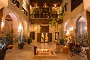 a large lobby with a fireplace in the middle of a building at Riad Hizad in Marrakesh