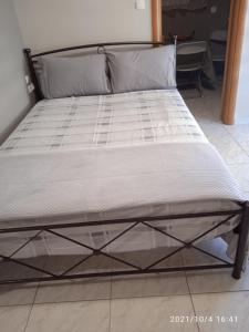 een bed in een kamer met een bedframe bij Apartment ARION 2 in Larisa