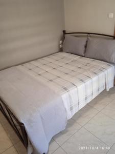 een bed in een kamer met een wit matras bij Apartment ARION 2 in Larisa