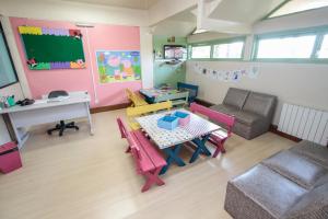 a living room with a table and chairs and a desk at Residencial Pousada do Serrano - 1 quarto in Gramado