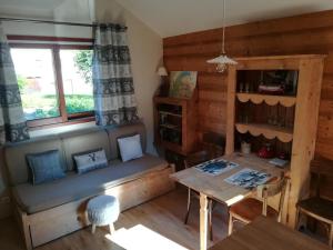 a living room with a couch and a table at Le Gîte de la Maison Soleil, entre lac et montagne in Alex
