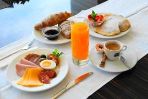 una mesa con platos de desayuno y una bebida en Gokart Hotel, en Kecskemét