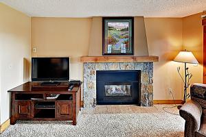 sala de estar con TV y chimenea en NorthStar 11 en Steamboat Springs