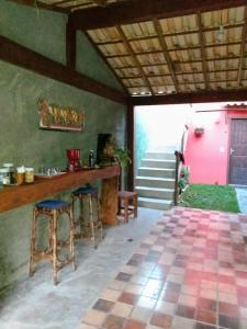a kitchen with a counter and stools in a room at Pouso da Lua in São Pedro da Serra