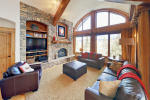 a living room with a couch and a stone fireplace at Hilltop Palace in Fraser