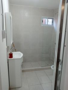 une salle de bain blanche avec une douche et un lavabo dans l'établissement Departamento Chacabuco, à San Fernando del Valle de Catamarca 1 autre photo