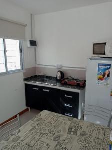 a kitchen with a refrigerator and a table with chairs at Departamento Chacabuco in San Fernando del Valle de Catamarca +1 photo