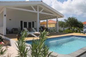 una piscina di fronte a una casa con padiglione di Kas Trupial a Willemstad
