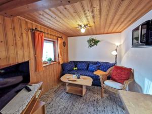 a living room with a blue couch and a table at Ferienwohnung Malerlehen in Schönau am Königssee