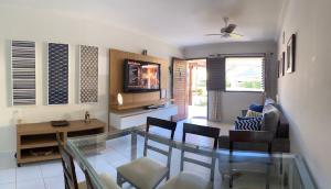 una sala de estar con una mesa y sillas de cristal en Casa em Antunes Maragogi Condomínio Beira Mar, en Maragogi