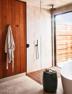 baño con bañera y puerta de ducha acristalada en Stanly Ranch, Auberge Resorts Collection, en Napa