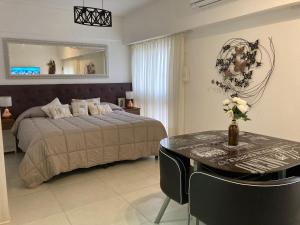 Un dormitorio con una cama, una mesa y un espejo. en 1353 Amplió y luminoso, en Mar del Plata