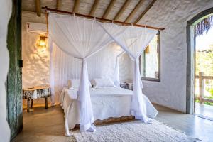 a bedroom with a bed with a canopy at Vila Rudá Trancoso in Trancoso