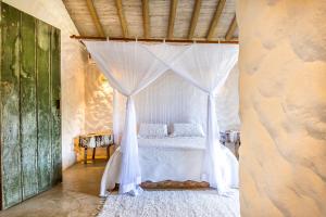a bedroom with a bed with a canopy at Vila Rudá Trancoso in Trancoso
