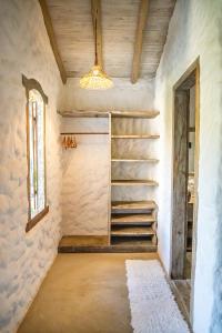 a room with stairs and a window and a chandelier at Vila Rudá Trancoso in Trancoso
