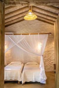 um quarto com 2 camas e um lustre em Vila Rudá Trancoso em Trancoso