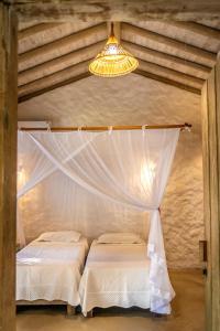 a bedroom with two beds and a chandelier at Vila Rudá Trancoso in Trancoso
