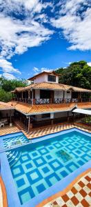 a villa with a swimming pool in front of a house at Casa Campestre Las Nieves in San Gil