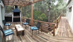 Una terraza con sillas, una mesa y una chimenea. en Balcón del Bosque, en Monte Hermoso