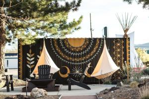 a tent with a banner and a chair in a yard at Amigo Motor Lodge in Salida