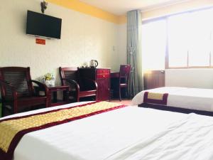 a hotel room with two beds and a television at Khách sạn Bình Dương in Quy Nhon