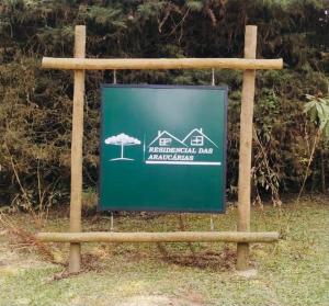 ein Schild auf einem Feld mit einem Haus darauf in der Unterkunft Residencial das Araucárias in Gonçalves