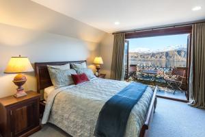 a bedroom with a bed and a large window with a view at Stoneridge Estate in Queenstown