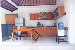 a kitchen with a wooden table and chairs at Sahadewa Suites Residence in Kerobokan