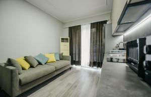 - un salon avec un canapé et une télévision dans l'établissement Bejart Apartment 1, à Tirana