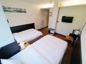 Posteľ alebo postele v izbe v ubytovaní 富裕商旅 RICH-hotel