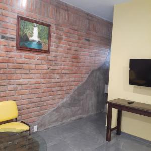 a room with a brick wall with a tv on it at Loft con jardín 1 in Puerto Vallarta