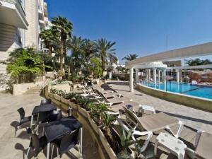 a resort with a pool and lounge chairs and a swimming pool at EILAT GOLF RESIDENCE Apartment A 1 in Eilat