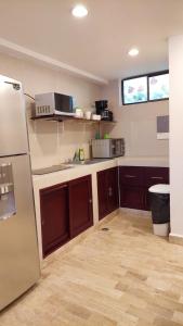 a kitchen with a refrigerator, stove, sink and microwave at Cancún Suites Apartments - Hotel Zone in Cancún