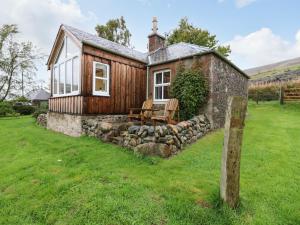 a tiny house with a stone retaining wall at The Bothy in Kirriemuir
