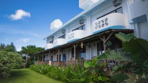 a large white building with a green yard at Sunset Beach House in Onna