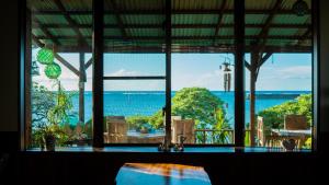 a room with a large window looking out at the ocean at Sunset Beach House in Onna