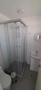 een badkamer met een douche, een toilet en een wastafel bij Deplaya Zorritos-Tumbes in Bocapán