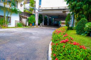una calle vacía al lado de un edificio con flores rojas en Sweet Home Hotel Betong, en Betong
