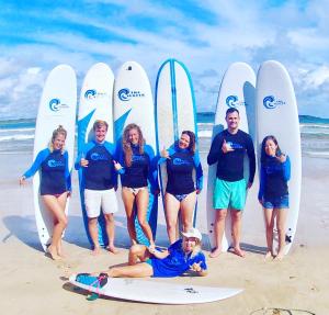 un grupo de personas de pie en la playa con tablas de surf en The Surfer Sri Lanka - Surf Camp, en Weligama