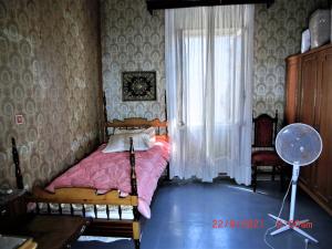 a bedroom with a bed with a pink blanket and a window at Ami's House only for WOMEN dormer in Corfu Town