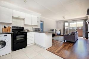 a kitchen with white cabinets and a black appliance at The Resting Nest in Midrand