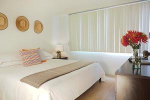 a white bedroom with a large bed and a window at Encantador Berlin By The Local Way in Mexico City